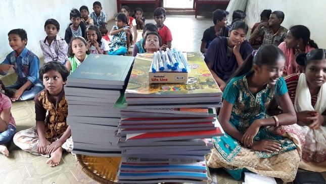 Children gathered with books and learning materials